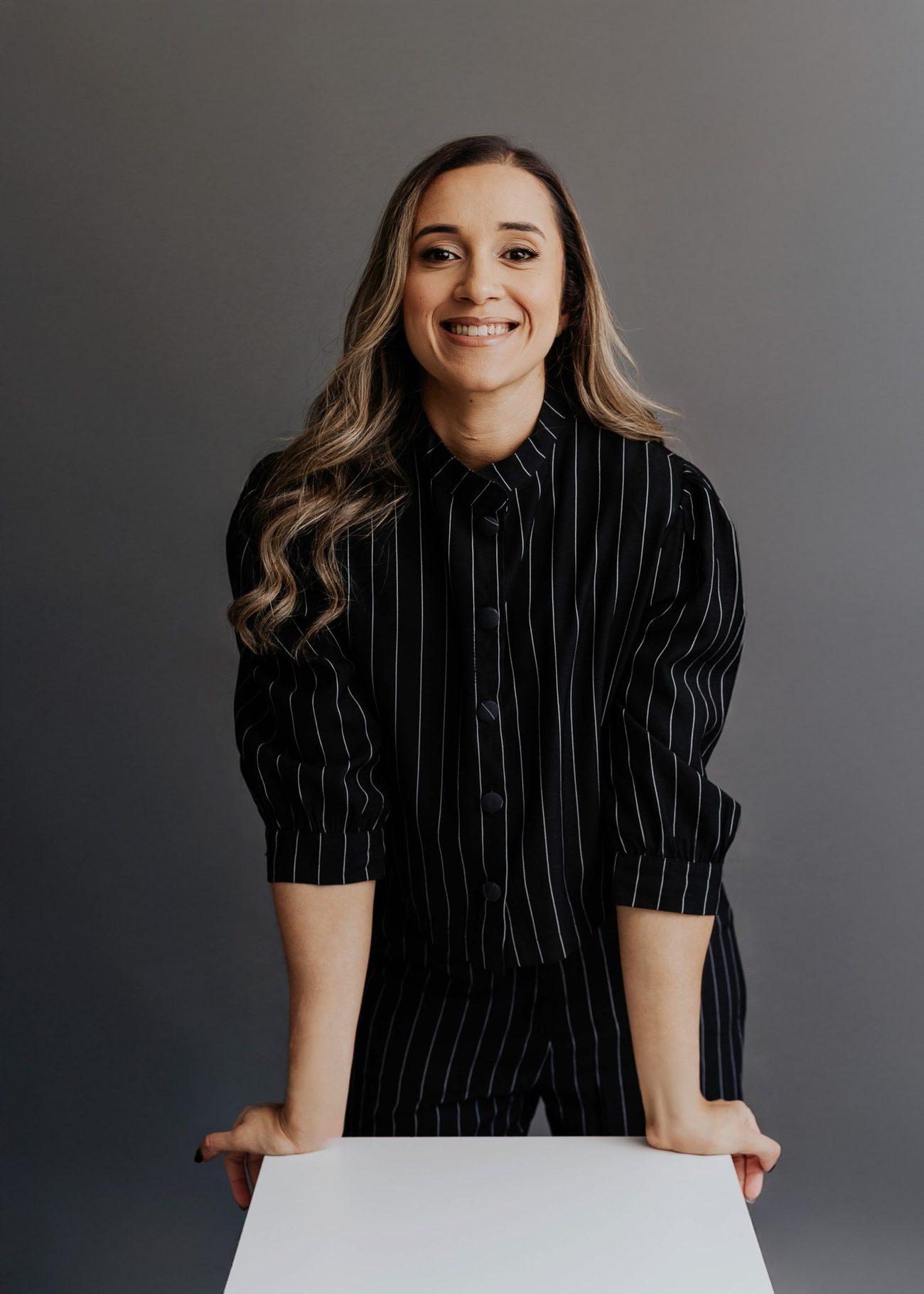 Dra. Rafaela Carvalho em fundo escuro, sorrindo